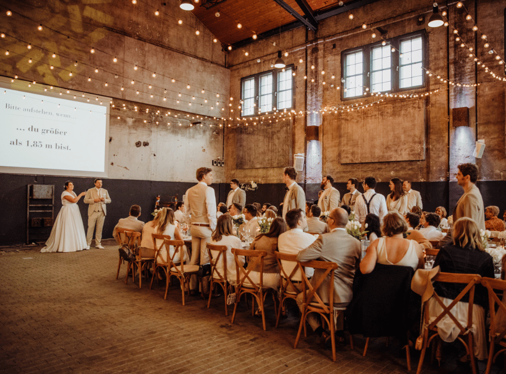 Hochzeitsgesellschaft während eines Hochzeitsspiels in der Alten Kesselhalle Solingen bei einer ausgelassenen Hochzeitsfeier