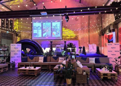 Stylisch beleuchtete Sitzlounge bei einer Gala in der Alten Maschinenhalle Solingen, bestehend aus Palettenmöbeln, Pflanzen und LED-Beleuchtung.