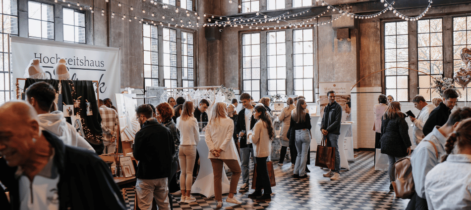Besucher einer Veranstaltung in der Alten Maschinenhalle Solingen vor historischer Industriekulisse