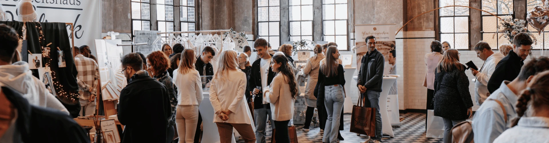 Besucher einer Veranstaltung in der Alten Maschinenhalle Solingen vor historischer Industriekulisse