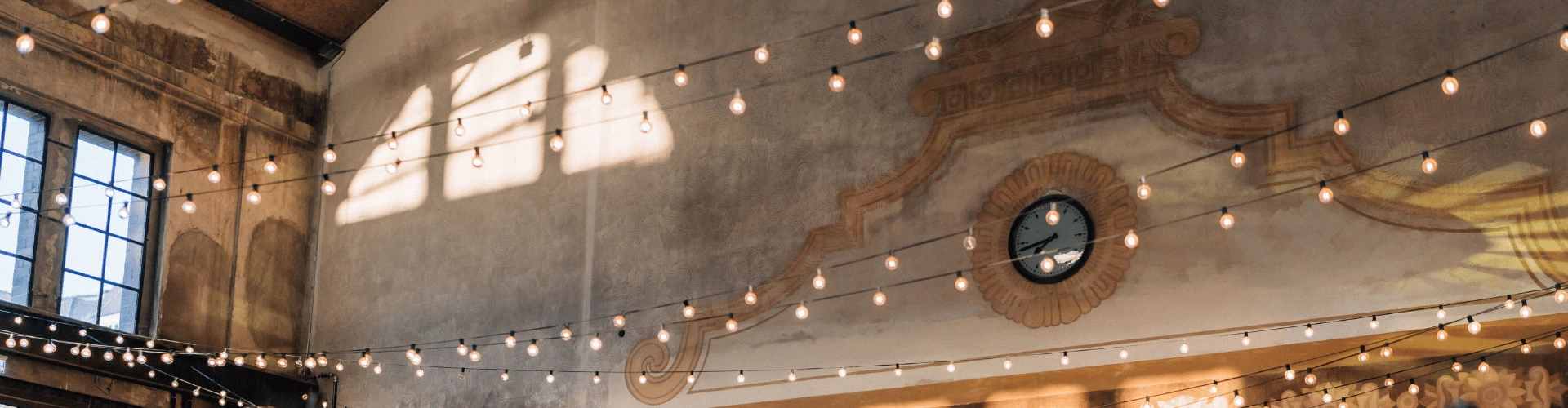 Wandmalerei, Wanduhr und Fenster im Innenraum der Alten Maschinenhalle