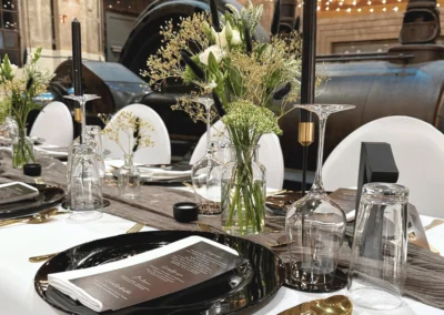 Hochzeitstisch mit Blumenvasen, Kerzenhaltern und eleganter Tischdekoration vor historischer Maschinenkulisse in der Alten Maschinenhalle Solingen.
