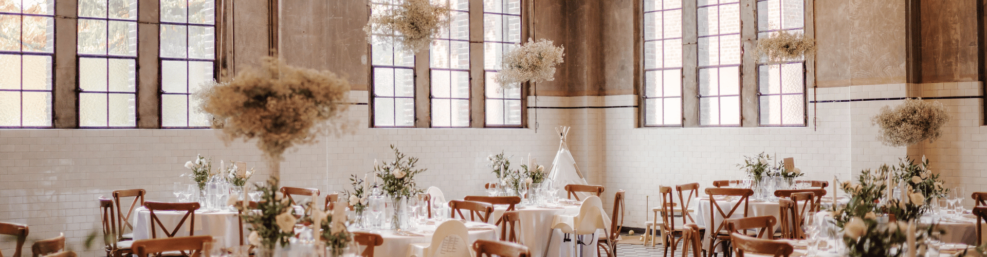 Festlich eingedeckte Hochzeitstische in der Alten Maschinenhalle Solingen mit Industriecharme, hohen Fenstern und liebevoller Dekoration