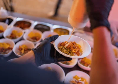 Ein Koch bereitet an einer Live-Cooking-Station in der Alten Kesselhalle Solingen frische Speisen in kleinen Schalen zu.