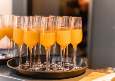 Ein Tablett mit eleganten Sektflöten, gefüllt mit Sekt und Orangensaft, bereit für den Empfang der Gäste in der Alten Kesselhalle.